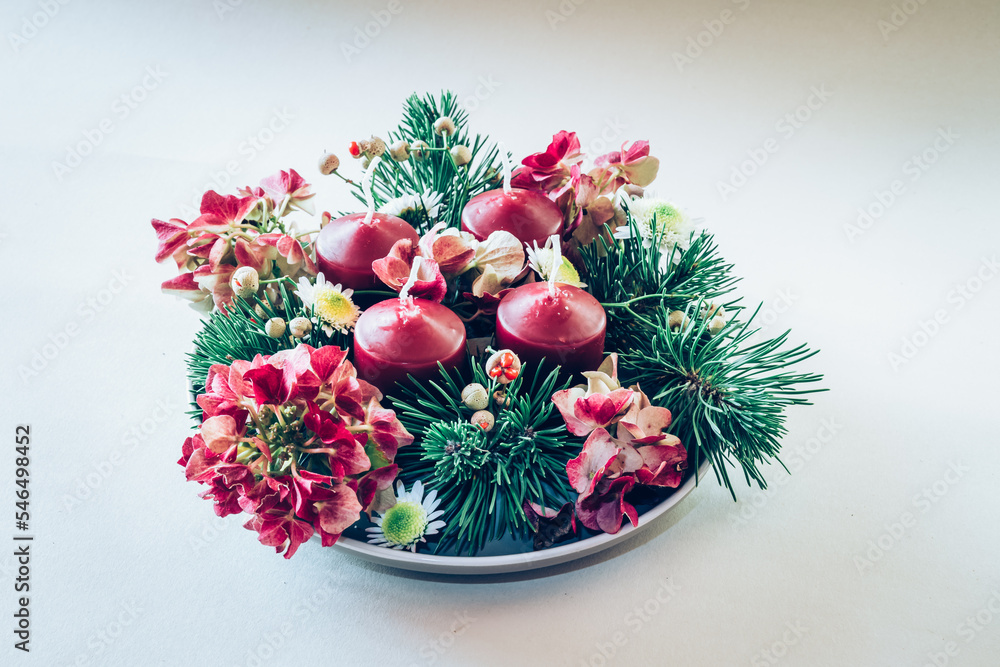 Wall mural four red advent candles burning on round wreath