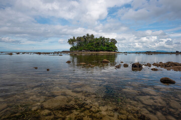 Small island and clear sea on blue sky background