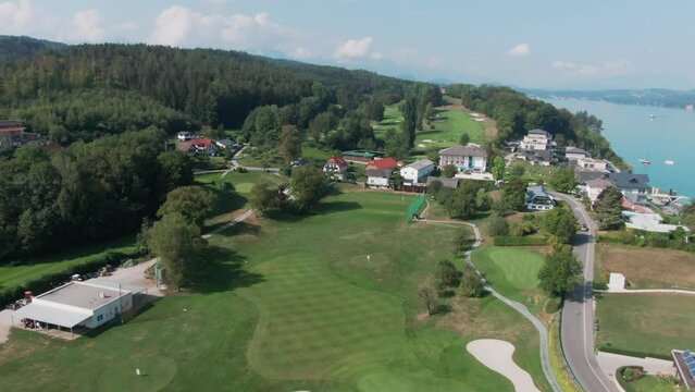 aerial drone footage of a beautiful golf course next to the W&ouml;rthersee in South Austria on a sunny day