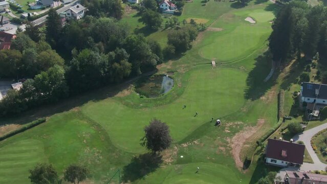aerial drone footage of a beautiful golf course next to the W&ouml;rthersee in South Austria on a sunny day