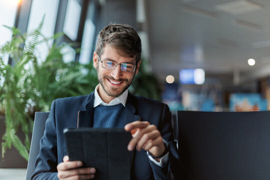 smiling man using a digital tablet during a trip.