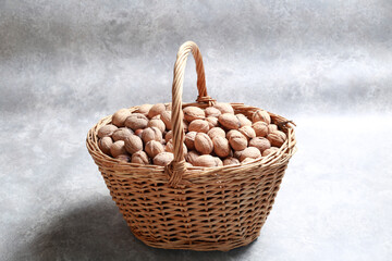 Basket full of walnuts on light background