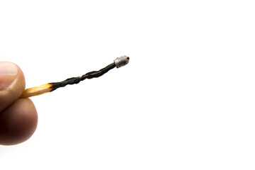 Burnt match stick in the hand on a white