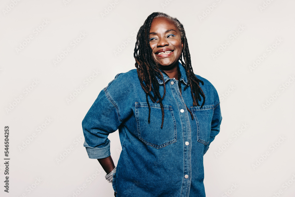 Wall mural woman with dreadlocks looking away with a smile in a studio