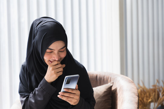 Muslim woman embracing islam ese mobile phone for shopping online