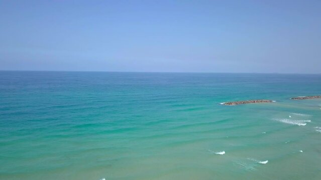 Sunny Summer Aerial in Israel, Ashkelon Beach - Flyby to the Ocean over rock dams