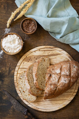 Bread from whole wheat grains, wheat bran, seeds, bio-ingredients over rustic table background. Homemade baking,  healthy lifestyle. View from above.