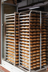 Fresh buns on the trays. Trays with bread stacked on the rack.