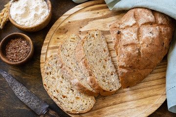 Bread from whole wheat grains, wheat bran, seeds, bio-ingredients over rustic table background....