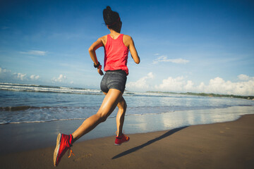 Young healthy lifestyle woman running at sunrise beach