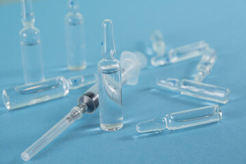 amula and syringe on a blue background. injection medicine. medicine and cosmetology