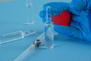 heart in hand. syringe and ampoules for injection. medicine and cosmetology