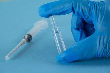 hand holding a test tube. a hand holds an ampoule for an injection. syringe and ampoule with medicine. cosmetology and medicine