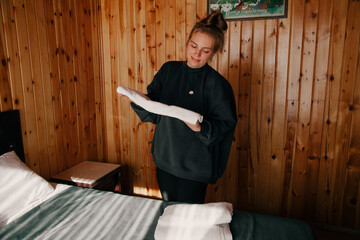 Caucasian woman doing choirs. Household concept. Woman putting pillowcases in the bedroom. Hotel...