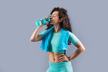 fitness woman with sport towel drinking water in studio. fitness woman hold towel drinking water