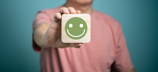 Man holding wooden disc with smiling face icons, customer satisfaction service, feedback, rating...