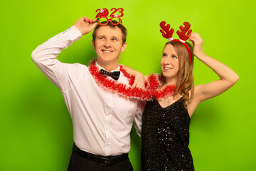 Two happy smiling people husband and wife or friends in funny party glasses, Christmas reindeer...