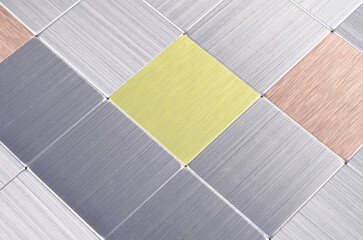 Modern panel with shiny silver and colored metal plates, grid wall background.