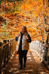 Woman walking in the autumn forest. A lake in the forest in autumn in Turkey.