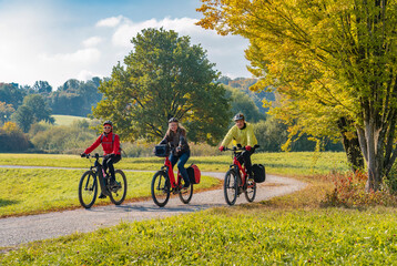 Fototapeta three happy senior adults, riding their mountain bikes in the autumnal atmosphere of the fall forests around city of Stuttgart, Baden Wuerttemberg, Germany
 obraz
