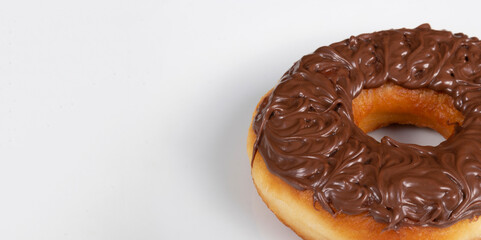 Tasty sweet donuts topped with chocolate and hazelnut cream served on a white plate. Close-up photo with empty space for texts on the left.