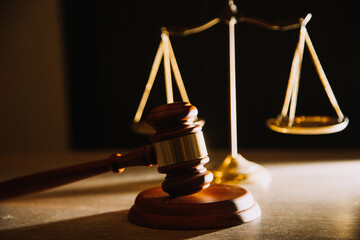 law books and scales of justice on desk in library of law firm. jurisprudence legal education...
