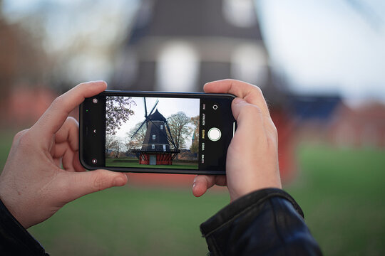 tourist takes a photo of Copenhagen windmill in the Citadel at Kastellet