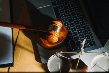 law books and scales of justice on desk in library of law firm. jurisprudence legal education...