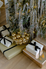 New Year's gift in gold color under the tree with balls in a basket at christmas