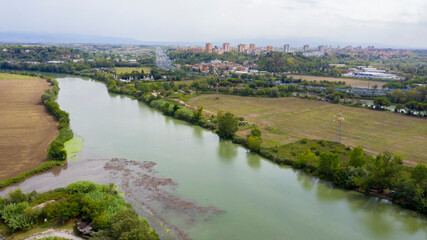 Fototapeta premium Aerial view on the sewage discharges that take place in the Tiber river, in Italy. Water changes color in contact with urban waste of Rome.