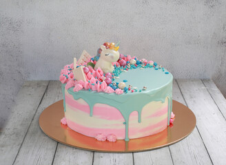 Cream dessert cake for children with pink and blue cream with a fabulous unicorn