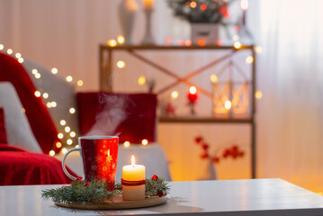 cup of hot drink with christmas decorations in white and red colors at home