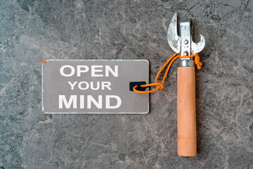 Can opener with a paper tag and message OPEN YOUR MIND