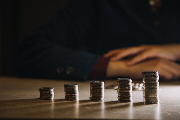 business woman hand calculating her money in the end of month with coin, calculator and calendar on wooden table