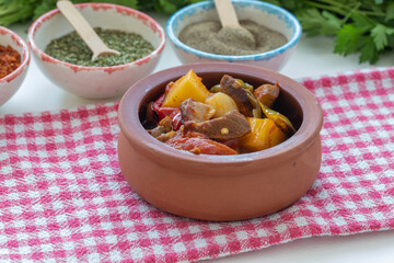 Meat casserole with vegetables in tomato sauce in a casserole. Top view with copy space.