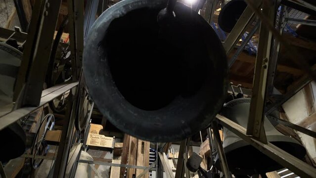 Big Bronze Bell Ringing in Church Clock Tower. Camera Tracking Motion.