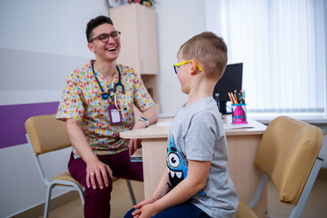 A child at the doctor’s office, the doctor listens to the boy’s lungs,
