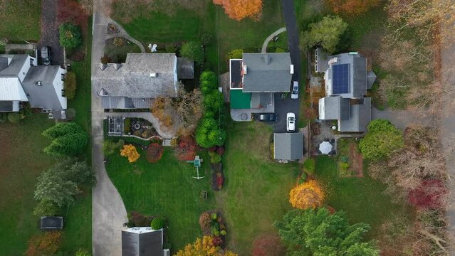 Top down aerial of mansions in American suburbs during autumn. Rooftop birds eye view.