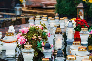All Saints' Day and burning candles and flowers on the graves.Candles on graves symbolize the memory of the dead on November 1.Catholic cemetery during All Saints' Day.Selective focus.