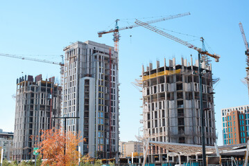 Construction site against blue sky. Exterior of multi-storey buildings under construction in city
