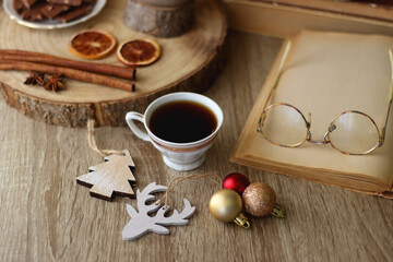 Cup of tea or coffee, various sweets and spices, Christmas decorations, comfy blanket, books and glasses. Selective focus.