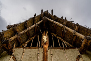 A bull skull on the wall at the entrance of a prehistoric hut