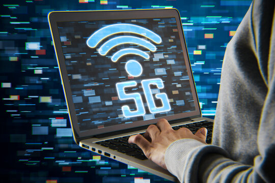 hacker hands holding laptop with 5G glitchy icon hologram on blurry backdrop. 5th Generation Wireless Internet Network connection information technology illustration, hacking concept. 