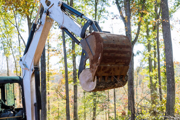 In conducts work on tractor manipulator lifts logs of process to prepare land for construction