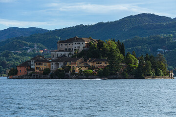 Fototapeta na wymiar Lake orta and the island of san giulio, an important tourist destination in piedmont, seen during a summer day from the town of Orta San Giulio, Italy - August 2022.