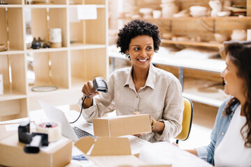 Happy online store owner scanning the barcode of a package box