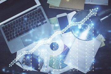Financial market graph and top view computer on the desktop background. Multi exposure. Investment concept.