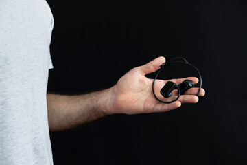 Man holding wireless headphones in his hand