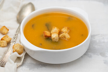 Vegetable cream soup with dry bread in white bowl