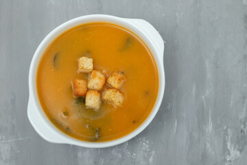vegetable soup with crackers in white bowl on ceramic